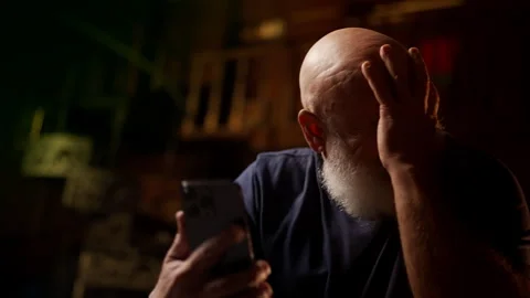 Desperate man in his 50s views family photos on phone and cries after divorce Stock Footage 342520615