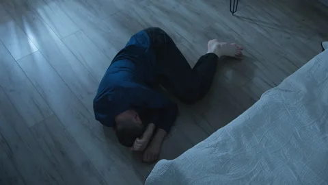 Desperate man lying on the floor in the room. Mental health, stress.  Stock Footage 286723312