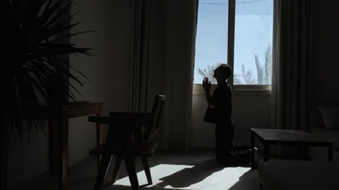 Desperate man praying on his knees in silhouette, seeking help and hope during Stock Footage 346243933