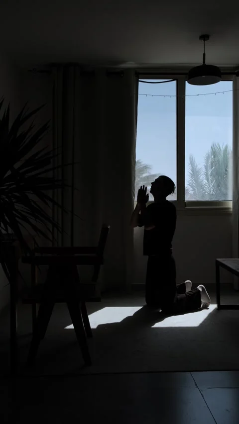 Desperate man praying on his knees in silhouette, seeking help and hope during Stock Footage 346246220