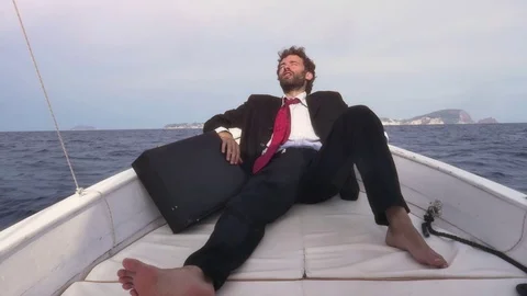Desperate man in suit with a briefcase sitting on the prow of a boat in the Stock Footage 78019267