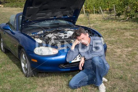 Desperate man waiting for assistance after breaking down in country Stock Photos
