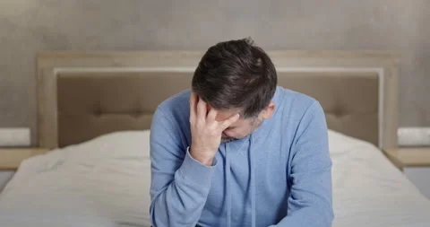 Desperate middle aged man crying on bed. Stressed mature male taking off glasses Video stock 151004990