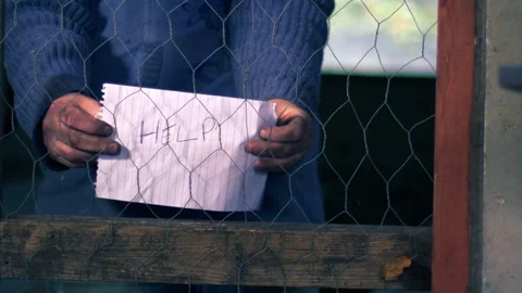 Desperate person asking for help from behind a wire fence Stock Footage 272797315