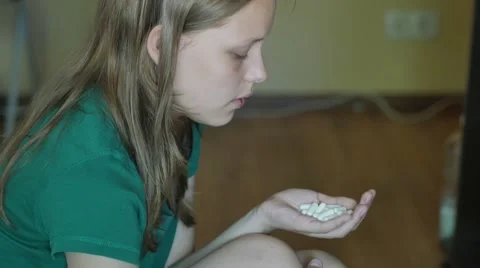 Desperate teen girl attempts to commit suicide with pills. 4K UHD Video stock 64652499