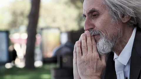 Desperate Upset gray-haired man closes his eyes praying, muttering and crying  Video stock 96490003