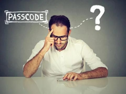 Desperate young man trying to log into his smart phone forgot password Stock Photos