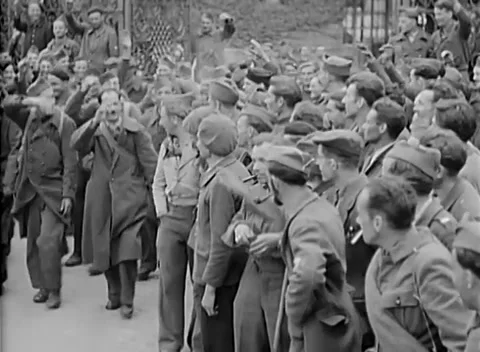 DESSAU, GERMANY - 1945: Men in caps - Dense crowd gathers below iron railings Stock Footage 344901034