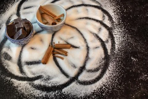 Dessert baking ingredients chunks of chocololate whole cinnamon sticks and sugar Stock Photos