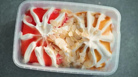 A dessert is being prepared with colorful layers in a clear container. Video stock 338447698