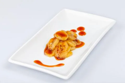 Dessert composed of fried bananas cut in slices and with liquid caramel Stock Photos