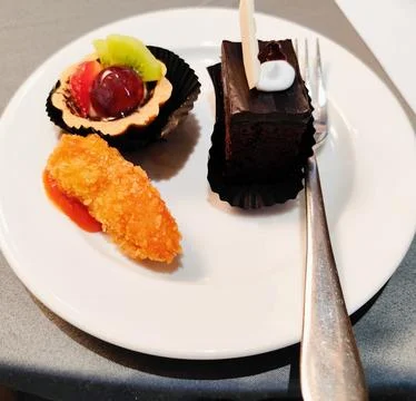 Dessert in the form of chocolate cup cake, pieces of strawberry, annona squ.. Stock Photos