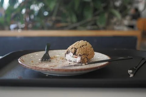 Dessert on a plate with fork at a cafe after being partly eaten Stock Photos