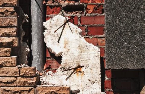 Destroyed, broken wall. On the site of a wall it is visible a red brick, fi.. Stock Photos
