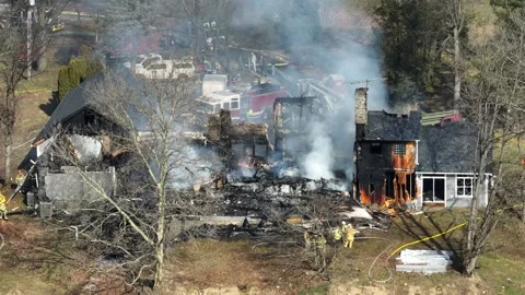 Destroyed building with ash and smoke during house fire. Sunny day in Stock Footage 265073555