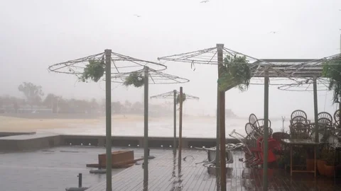Destroyed cafe umbrellas by the sea during a hurricane. Storm in Barcelona Stock Footage 123547313