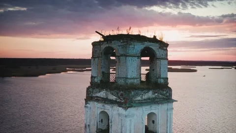 Destroyed lighthouse tower with collapsed roof and overgrown grass against the Stock Footage 223048429