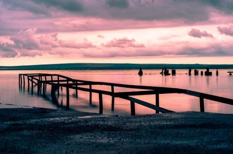 Destroyed pier on the lake at sunset Stock Photos