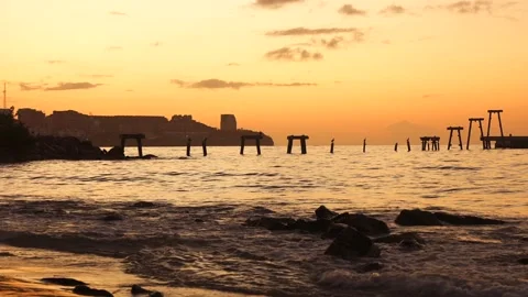 Destroyed pier at sunrise. Calm waves crashing on the stones at the beach Stock Footage 231136626