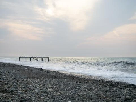 Destroyed pier under the waves. Bad weather at sea. Beautiful seashore with.. Stock Photos