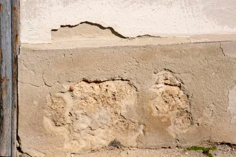 Destroyed plaster on a house wall which falls off Stock Photos