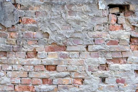 Destroyed plaster on an old red brick wall. Grunge background Stock Photos
