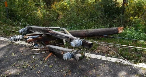 Destroyed power pole top CU with insulators, broken parts lays on road side Stock-Footage 99124240