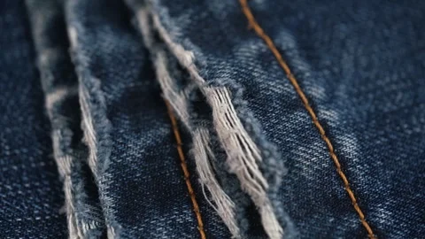 Destroyed texture of bottom edge of legs worn torn blue jeans. closeup rotation. Stock Footage 253301984