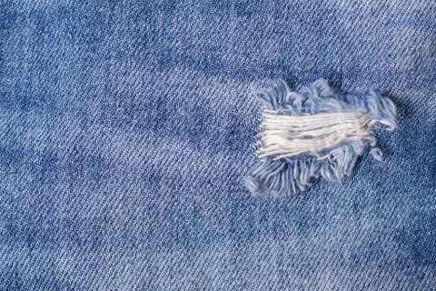 Destroyed Torn Blue jeans background. Close up blue textures ripped jeans Stock Photos