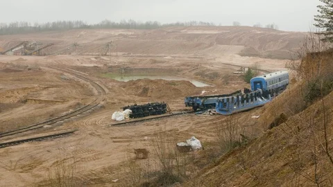 Destroyed train among the sand ballast quarry on the cloudy summer day Stock Footage 127409533