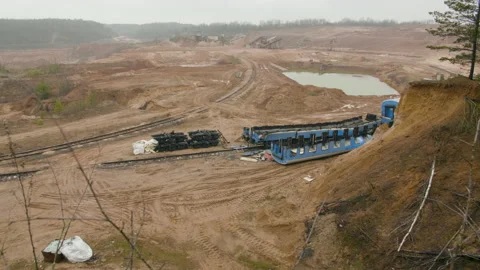 Destroyed train among the sand ballast quarry on the cloudy summer day Stock Footage 134648207