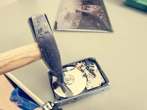 Destroying computer hard drive with a hammer. Stock Photos