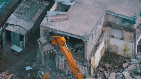 Destroying Old Concrete House Using Mechanical Arm of Bulldozer on Construction Foto stock