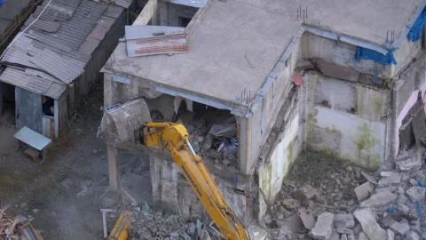Destroying Old House Using Bucket Excavator on Construction Site. Foto stock