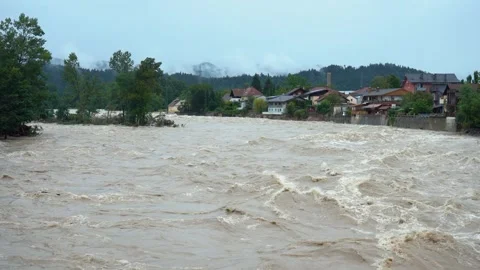 A destructive river with raging dirty brown water rushes down its bed Stock Footage 247395480