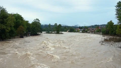 A destructive river with raging dirty brown water rushes down its bed Stock Footage 247395498