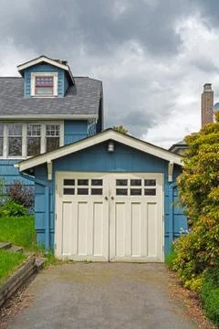 Detached single stall garage on front yard of residential house Stock Photos