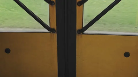 Detail of an automatic yellow school bus door closing. The green landscape Stock Footage 345876524