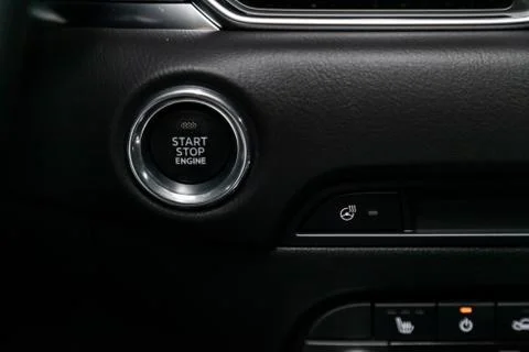 Detail on a black start stop engine  button in a car.Car detailing. Stock Photos