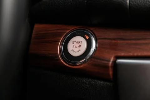 Detail on a black start stop engine  button in a car.Car detailing. Stock Photos