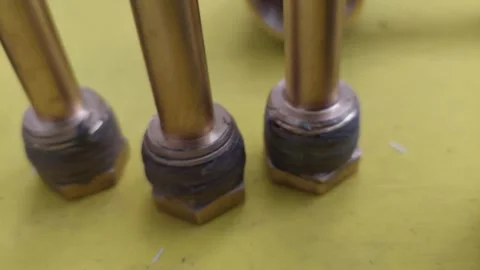 Detail of brass extension tubes with thread sealant on yellow background Stock Footage 336901969