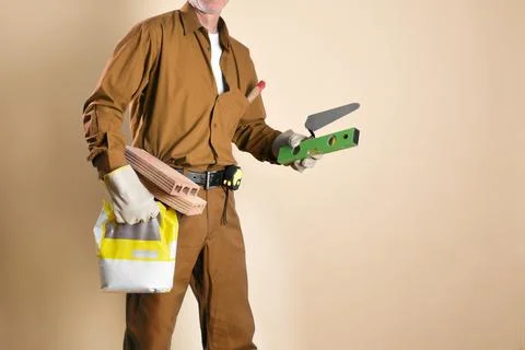 Detail of bricklayer holding tools and building materials isolated Stock Photos