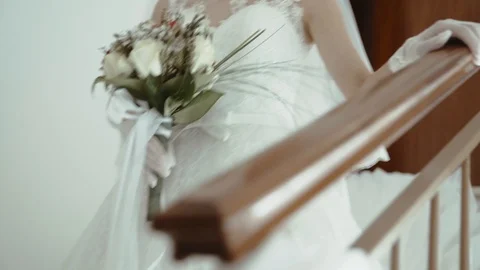Detail of the bride going down the stairs with the bouquet. Stock Footage 92601398