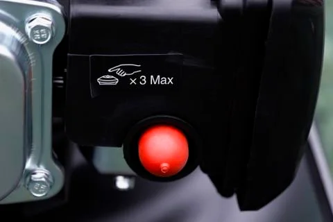 Detail of the choke button of a mower's engine with its warning Stock Photos