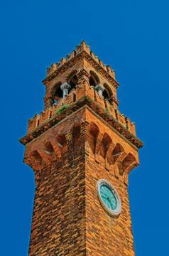 Detail of clock tower made of bricks with sunny blue sky  at Murano Stock Photos