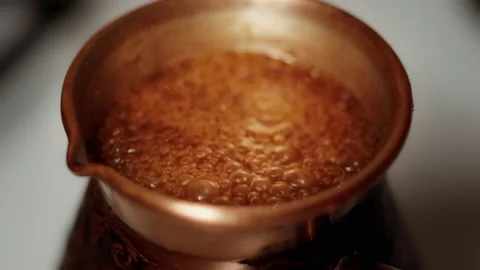 A detail of coffee burning down rapidly in the modern brown copper jezve Video stock 148169359