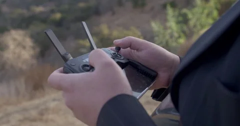 Detail of drone pilot hands operating quadcopter during day 4K Stock Footage 83673119