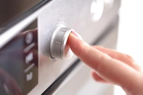 Detail of female hand while using the microwave Stock Photos