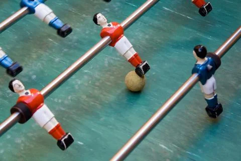 Detail of foosball table with toy players and yellow ball Stock Photos