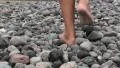 Detail of guy legs walking in the gravel on the beach HD Footage